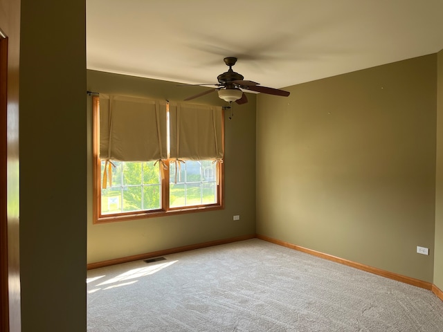 carpeted spare room with ceiling fan