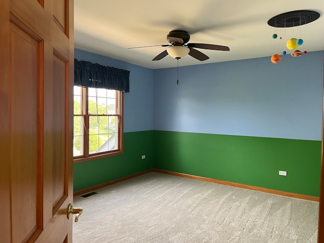 carpeted spare room with ceiling fan