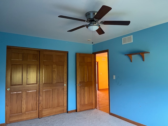 unfurnished bedroom featuring a closet, light carpet, and ceiling fan