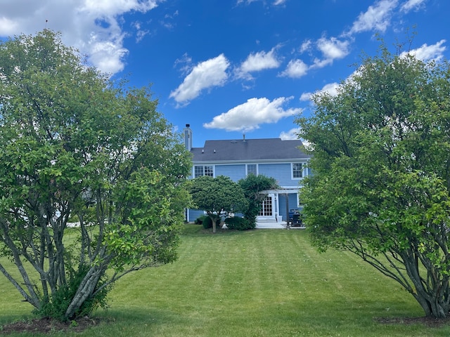 rear view of property featuring a lawn