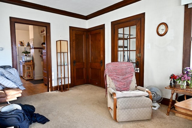 living area featuring crown molding and carpet