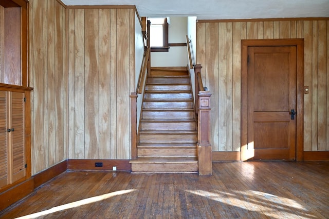 staircase featuring hardwood / wood-style flooring and wood walls