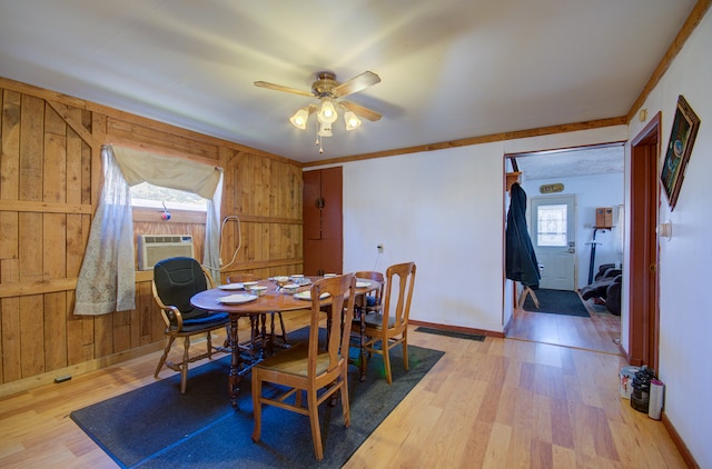 dining space featuring wood walls, hardwood / wood-style flooring, ceiling fan, and cooling unit