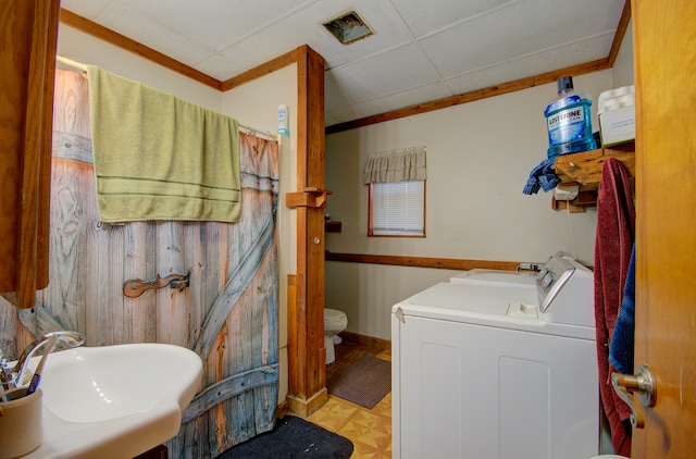 bathroom featuring separate washer and dryer, sink, toilet, and ornamental molding