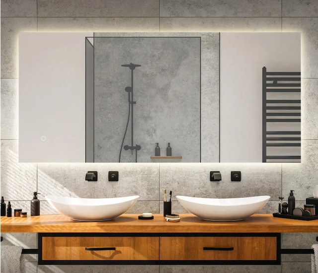 bathroom featuring tasteful backsplash, radiator, vanity, and walk in shower