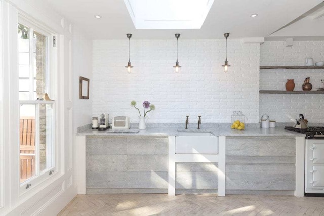 bar featuring pendant lighting, a skylight, sink, and light parquet floors