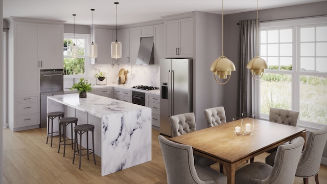 kitchen featuring stainless steel appliances, ventilation hood, pendant lighting, decorative backsplash, and a kitchen island