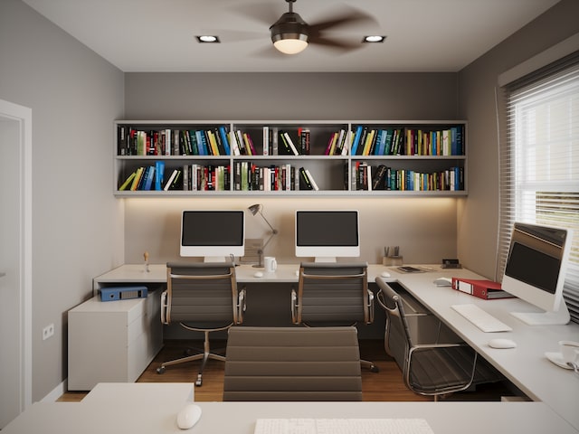 office featuring wood-type flooring, built in desk, and ceiling fan