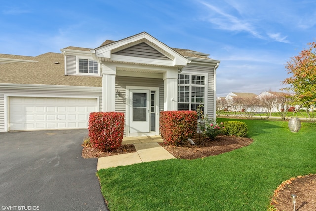 view of front of home with a front lawn and a garage