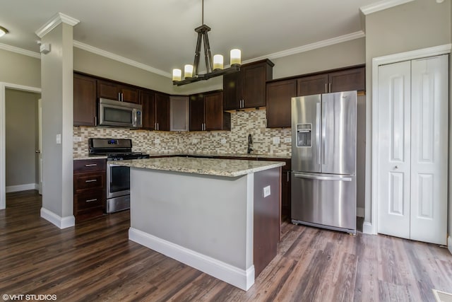 kitchen with appliances with stainless steel finishes, crown molding, hanging light fixtures, and dark wood-type flooring