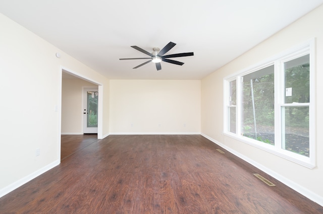 spare room featuring dark wood-type flooring and ceiling fan