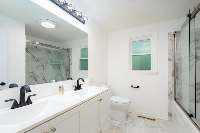 full bathroom featuring enclosed tub / shower combo, vanity, and toilet