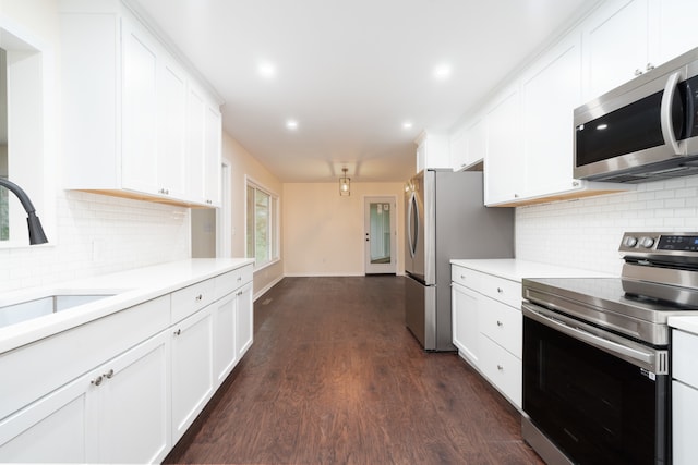 kitchen with stainless steel appliances, white cabinetry, and dark wood-type flooring