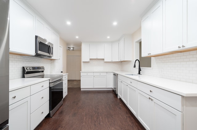 kitchen with sink, appliances with stainless steel finishes, dark hardwood / wood-style floors, backsplash, and white cabinets