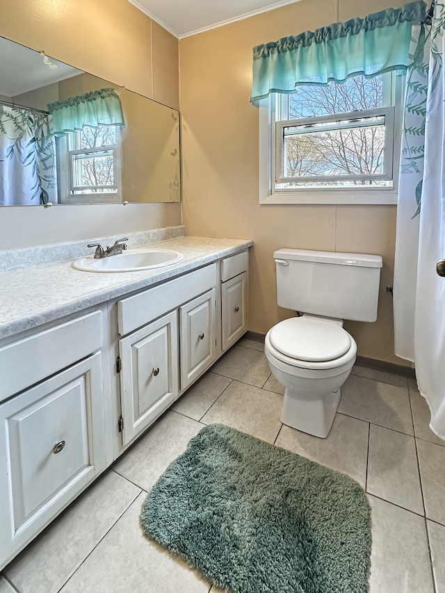 bathroom with tile patterned flooring, vanity, toilet, and a wealth of natural light