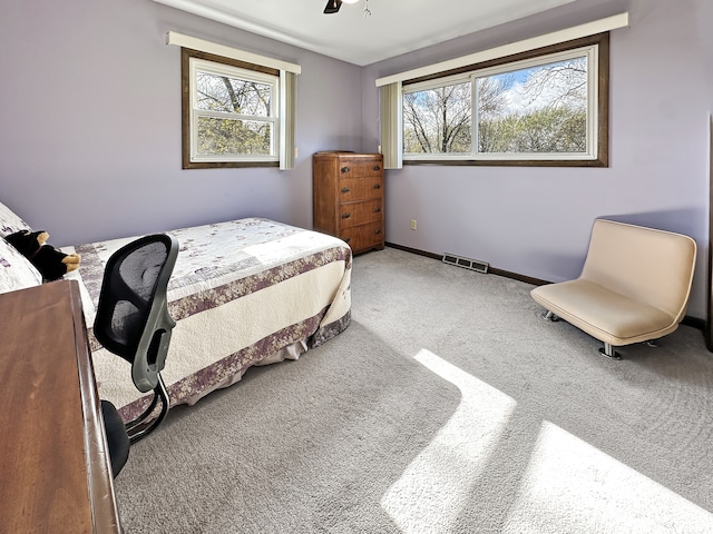 carpeted bedroom with ceiling fan and multiple windows