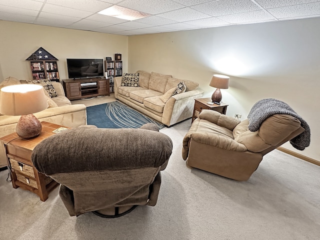 living room with a paneled ceiling and light colored carpet