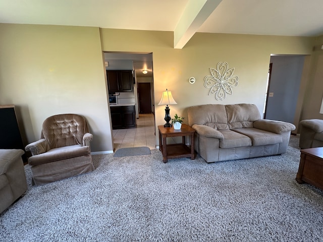 carpeted living room with beam ceiling