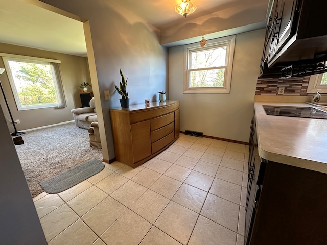 interior space featuring backsplash, plenty of natural light, and light tile patterned floors