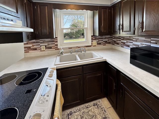 kitchen featuring dark brown cabinetry, sink, range hood, backsplash, and electric stove