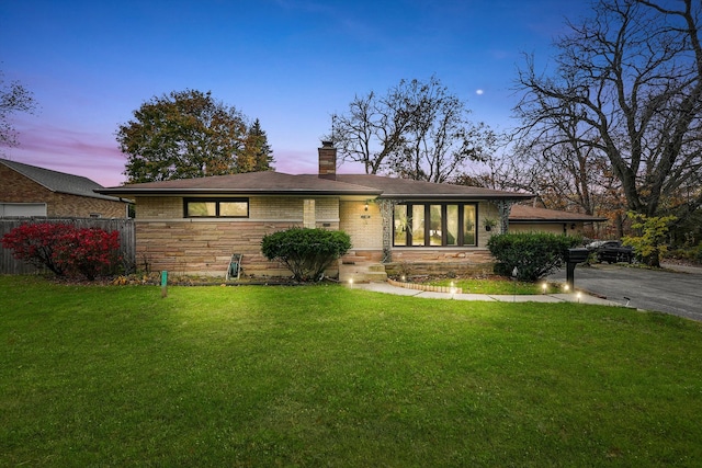 ranch-style home with a yard