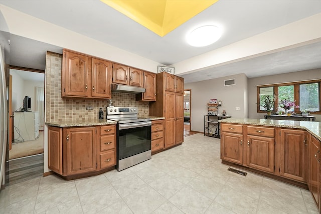 kitchen featuring decorative backsplash, light stone countertops, and stainless steel electric range