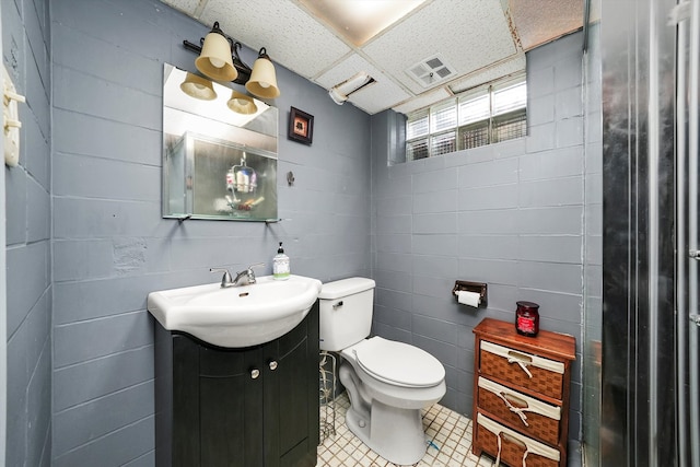 bathroom featuring vanity, toilet, and a paneled ceiling