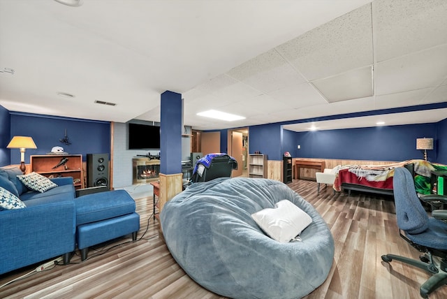 living room featuring a paneled ceiling and hardwood / wood-style flooring