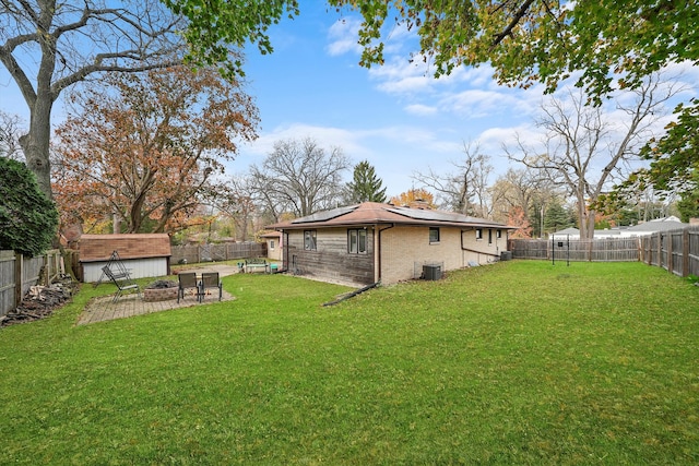 view of yard with a storage unit, cooling unit, and a patio area