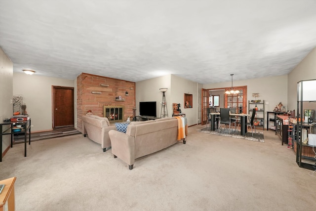 carpeted living room with a fireplace and a chandelier