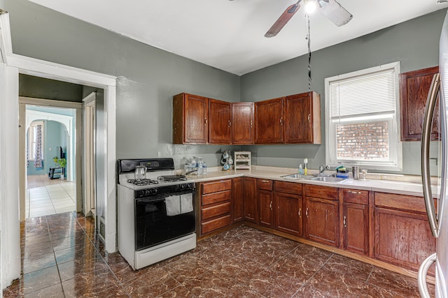 kitchen with gas range gas stove, ceiling fan, and sink