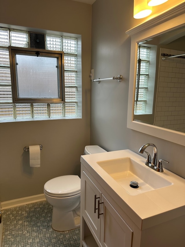 bathroom featuring tile patterned flooring, plenty of natural light, toilet, and vanity