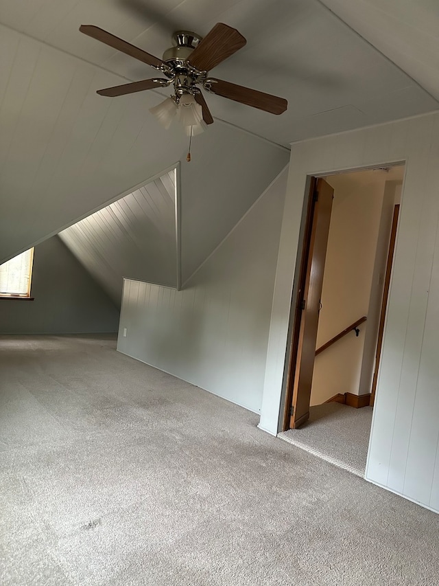 additional living space with ceiling fan, light colored carpet, and vaulted ceiling