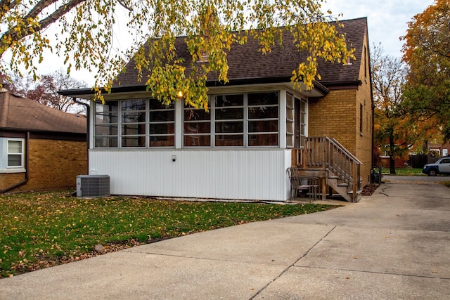 view of home's exterior with central air condition unit and a yard