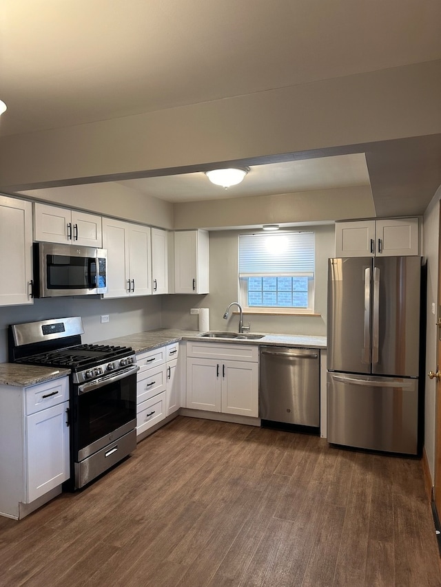 kitchen with white cabinets, appliances with stainless steel finishes, dark wood-type flooring, and sink