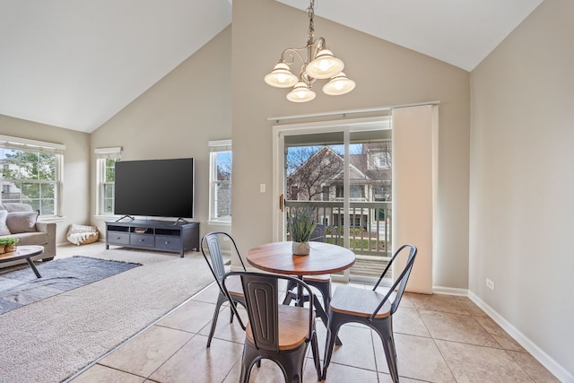 tiled dining area featuring high vaulted ceiling and an inviting chandelier