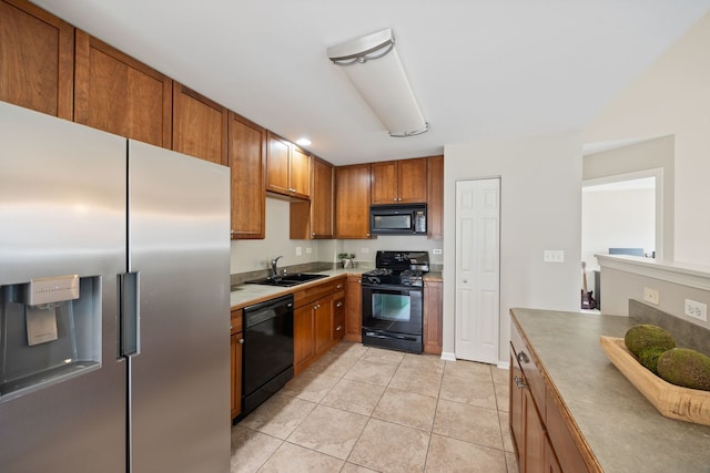 kitchen featuring light tile patterned floors, sink, and black appliances