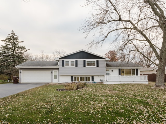 split level home featuring covered porch, a garage, and a front lawn