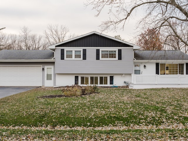 tri-level home with a front yard, a porch, and a garage