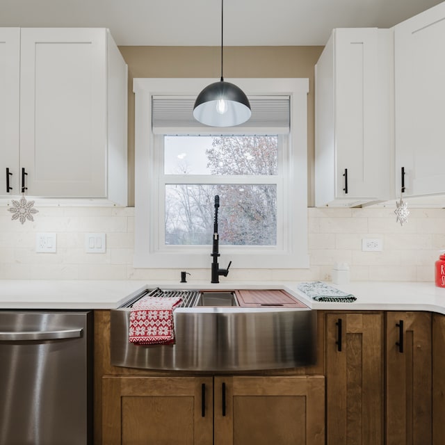 kitchen featuring white cabinets, pendant lighting, backsplash, and dishwasher