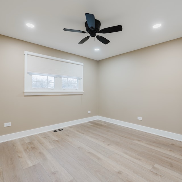 empty room with ceiling fan and light hardwood / wood-style flooring