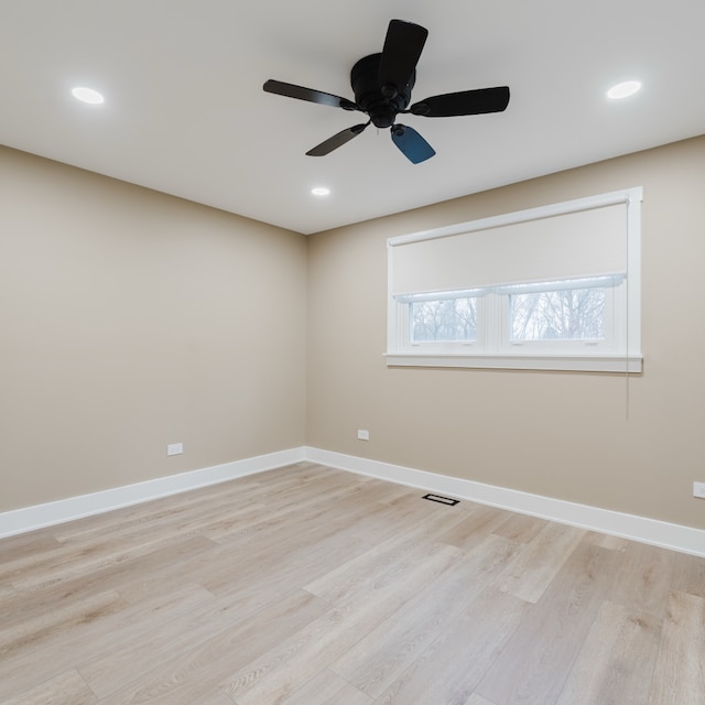 spare room with ceiling fan and light wood-type flooring