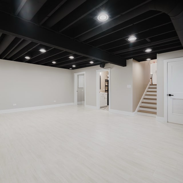 basement with light hardwood / wood-style flooring