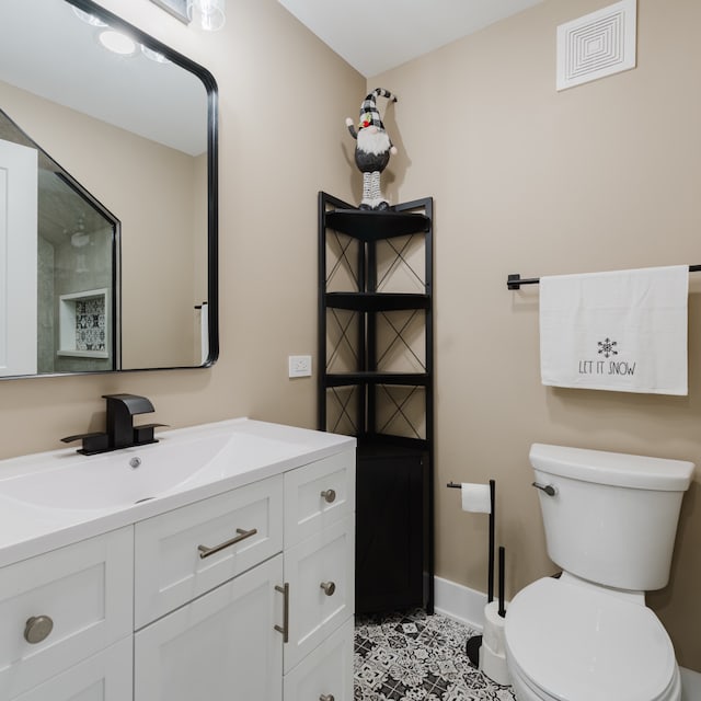 bathroom with tile patterned flooring, vanity, and toilet