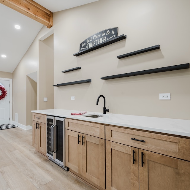 bar featuring vaulted ceiling with beams, light wood-type flooring, beverage cooler, and sink