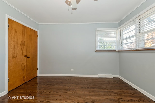 spare room featuring dark hardwood / wood-style floors, ceiling fan, and crown molding