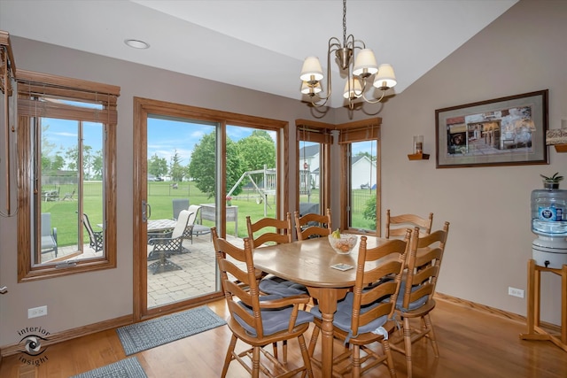 dining space with a chandelier, lofted ceiling, and light wood-type flooring