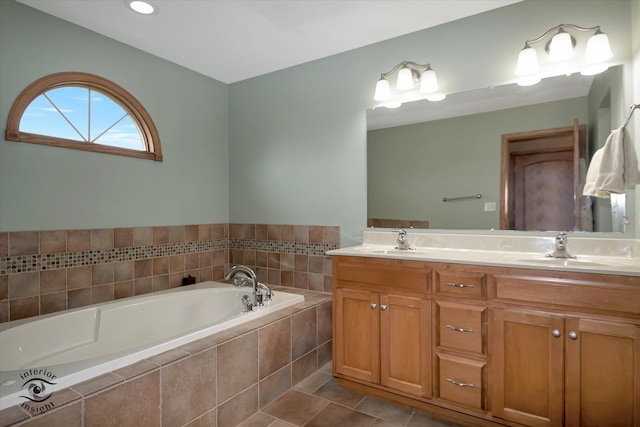 bathroom with tile patterned floors, tiled bath, and vanity