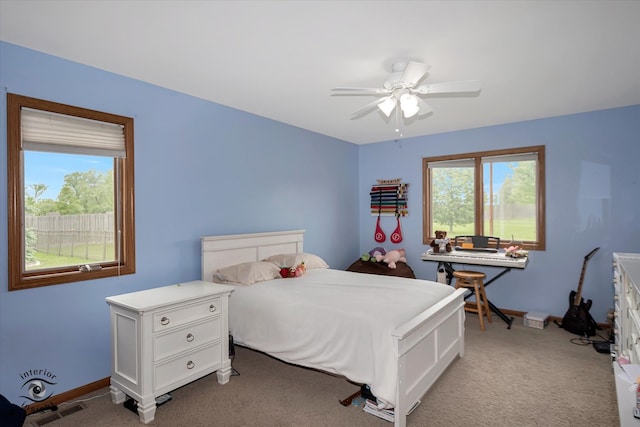 bedroom with light carpet, multiple windows, and ceiling fan