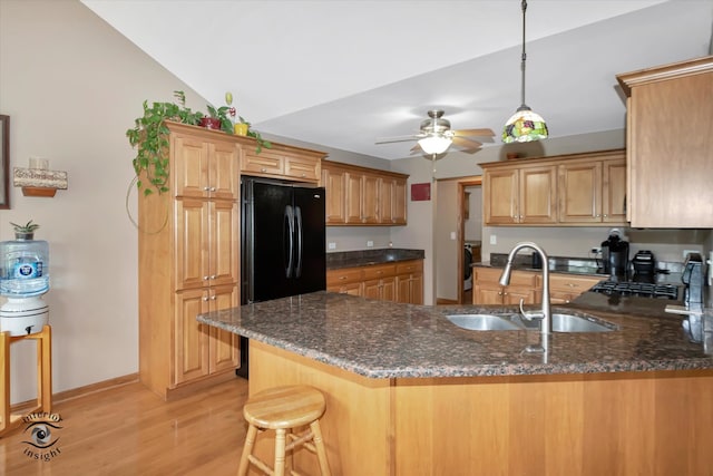 kitchen with sink, vaulted ceiling, ceiling fan, light wood-type flooring, and kitchen peninsula